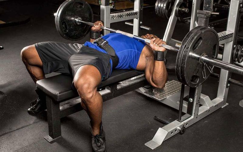 Thực hiện động tác đẩy ngực trên ghế băng để làm nóng các cơ