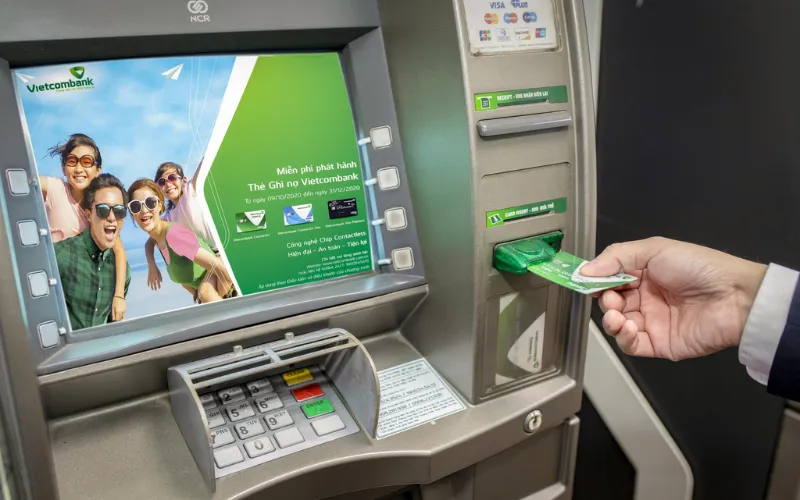 Đến cây ATM của ngân hàng bạn đang sử dụng và đưa thẻ vào khe nhận thẻ